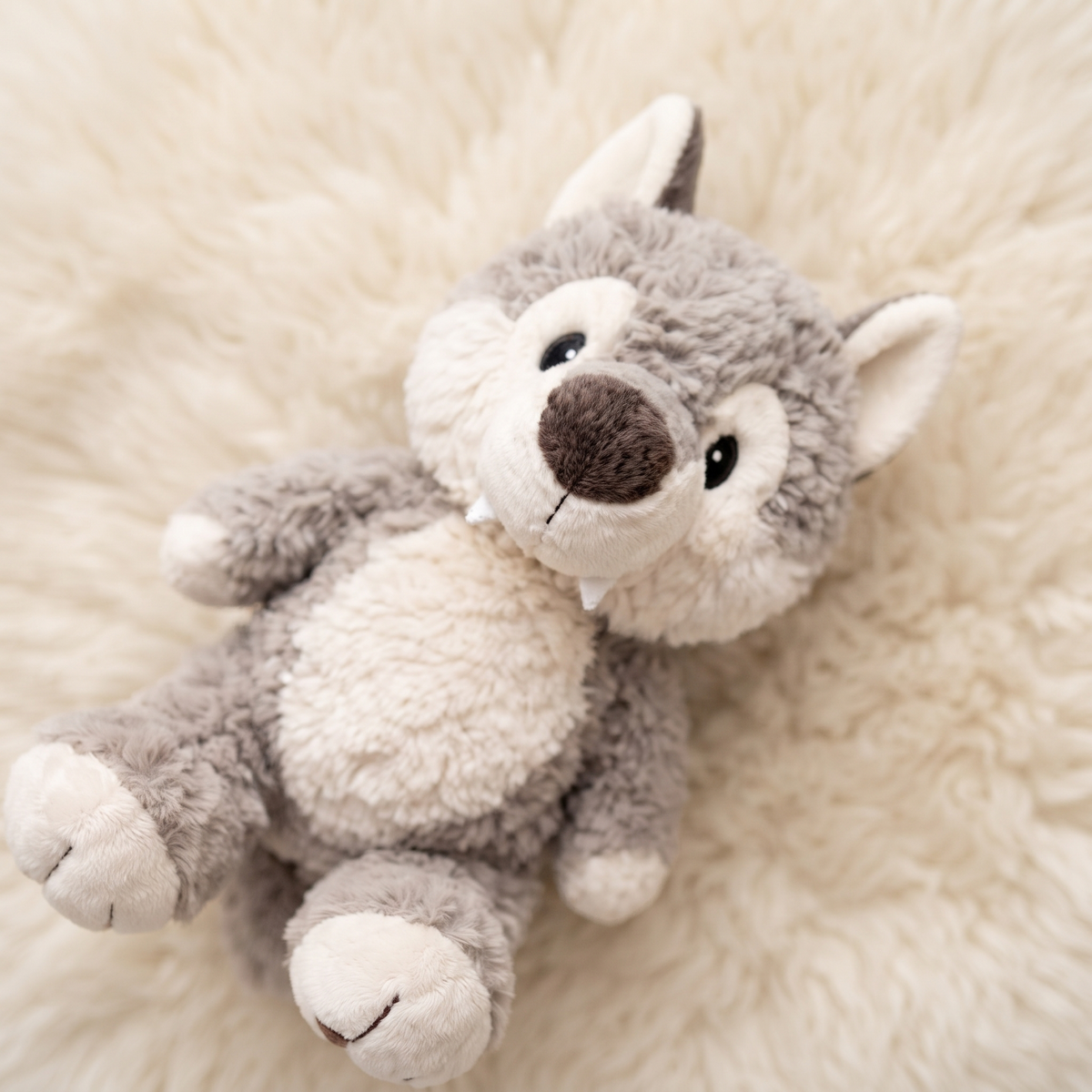 Zittende grijze wolf knuffel