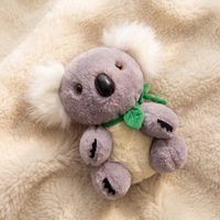 Grijs-witte koala knuffel met eucalyptusblad